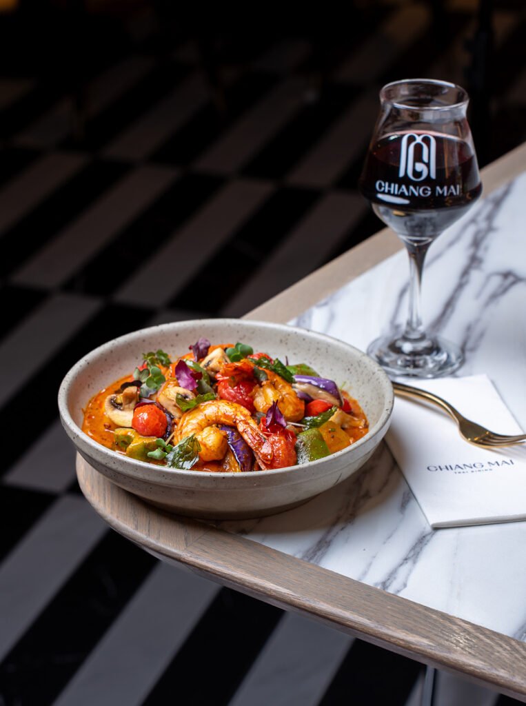 Delicious shrimp and vegetable stir-fry served with a glass of red wine.