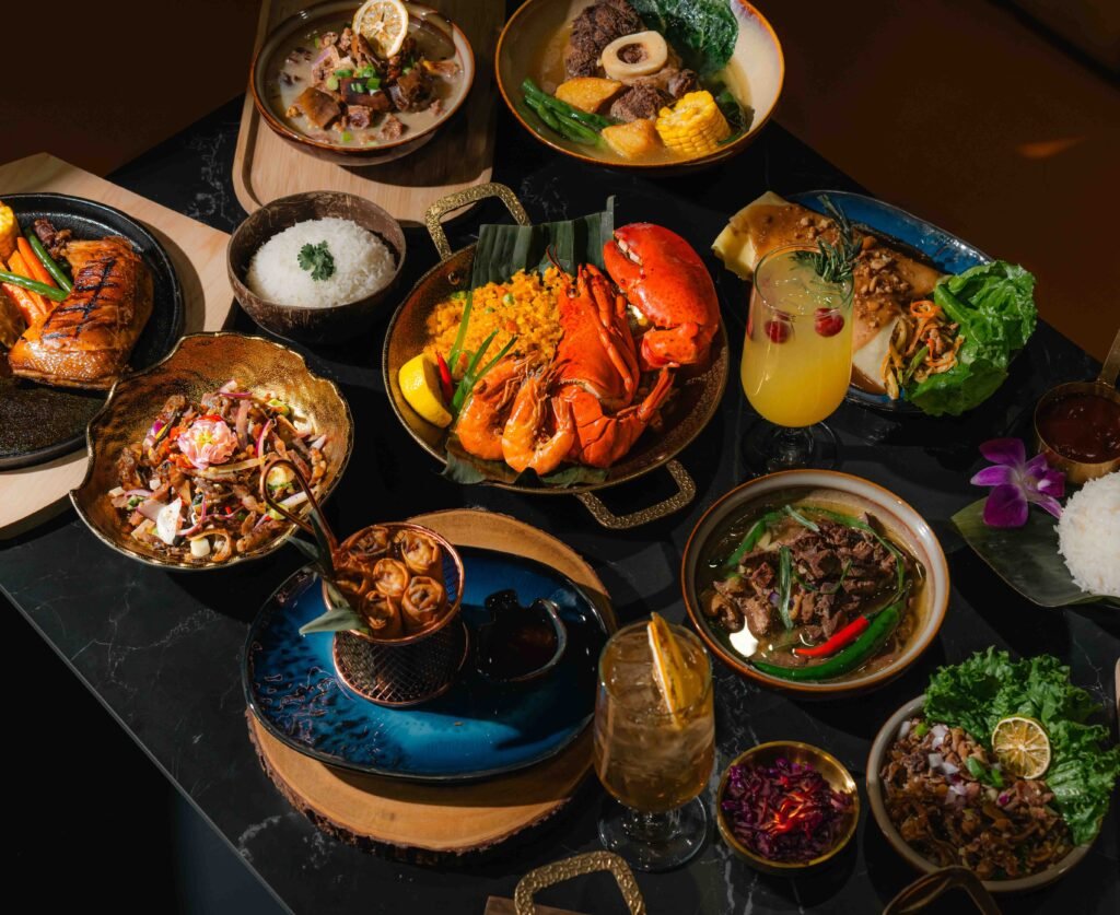 A top-down view of a table filled with a variety of colorful Asian dishes, expertly captured by a toronto-food-photographer, including seafood, grilled meat, rice, curry, soup, salads, and drinks on elegant serving plates and bowls.